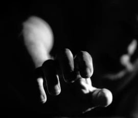 Reaching Through Shadow Black and white fine art image of Larry reaching toward the camera, with the hand sharply lit and the face softly blurred in the background.