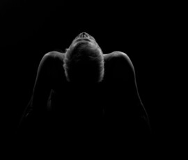 Head Back in Shadow Black and white fine art image of Larry with head tilted back, shoulders outlined by rim light against a dark background.